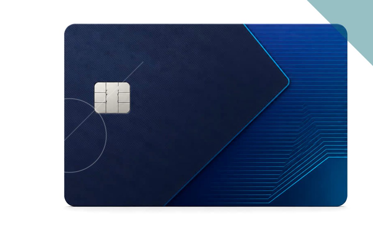 Pessoa segurando um cartão de crédito sobre a mesa com notebook, representando o uso de um cartão de crédito empresarial ideal para MEIs no dia a dia profissional.